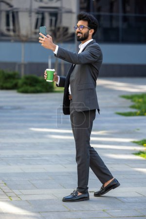 Téléchargez les photos : Elégant jeune homme d'affaires faisant une pause café et selfie - en image libre de droit