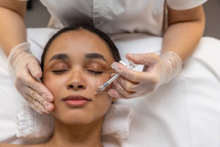 Foto de En el salón de belleza. esteticista haciendo inyecciones faciales a una paciente femenina - Imagen libre de derechos