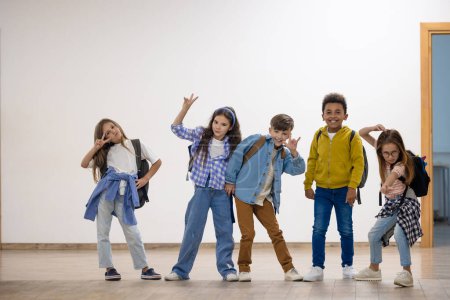 Foto de Grupo de niños de primaria de pie en el pasillo de la escuela durante el descanso. - Imagen libre de derechos
