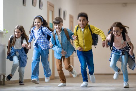 Foto de Grupo de niños de la escuela primaria corriendo en el pasillo escolar durante el descanso. - Imagen libre de derechos