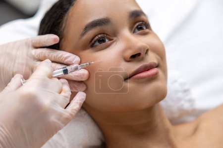 Foto de Mesoterapia. Mujer joven de piel oscura que tiene una sesión de mesoterapia - Imagen libre de derechos