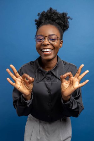 Téléchargez les photos : Femme afro-américaine excitée souriant et regardant positif - en image libre de droit