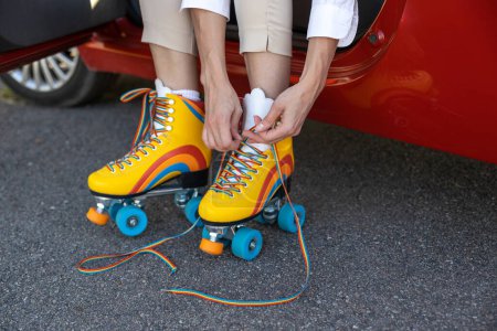 Photo for Unknown woman wearing roller skates while sitting in her automobile - Royalty Free Image