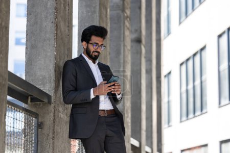 Photo for Stylish young businessman in office area with a phone in hands - Royalty Free Image