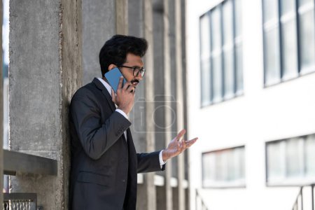 Photo for Young businessman having a phone conversation and looking excited - Royalty Free Image