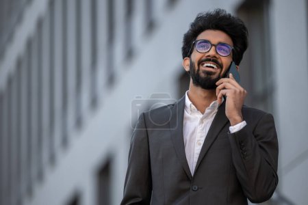 Photo for Hindu businessman having a phone call and looking confident - Royalty Free Image