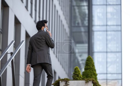 Téléchargez les photos : Grand homme avec téléphone dans les mains dans la zone de bureau - en image libre de droit