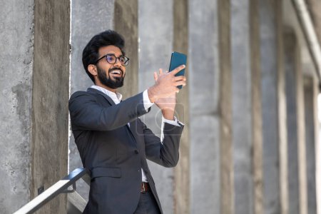 Foto de Joven empresario hindú guapo con un teléfono en las manos - Imagen libre de derechos