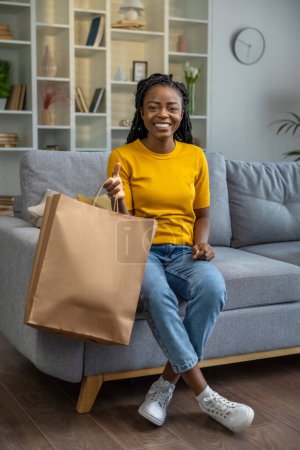 Téléchargez les photos : Jeune femme ouverture livraison de boutique en ligne et regarder satisfait - en image libre de droit