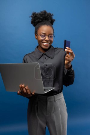 African american business woman with a credit card and a laptop in hands