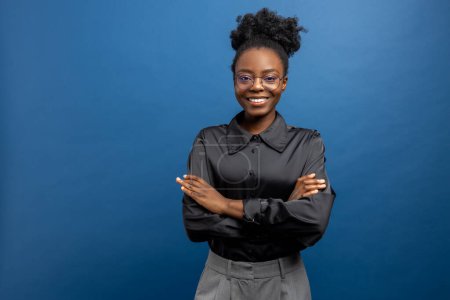 Dark-skinned young woman in black silky shirt looking confident
