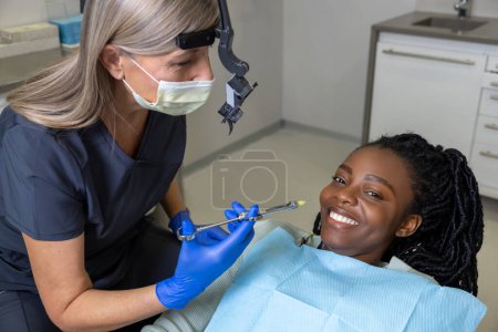 Photo for Dentist checking teeth of patient woman sitting in medical center professional oral care - Royalty Free Image