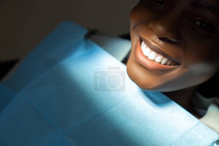 Foto de Paciente femenina multicultural adulta con la boca abierta en el consultorio del dentista que fija sus dientes - Imagen libre de derechos