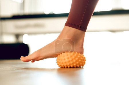 Foto de Relajación miofascial de los músculos del pie con bola de masaje para prevenir la fatiga del pie - Imagen libre de derechos