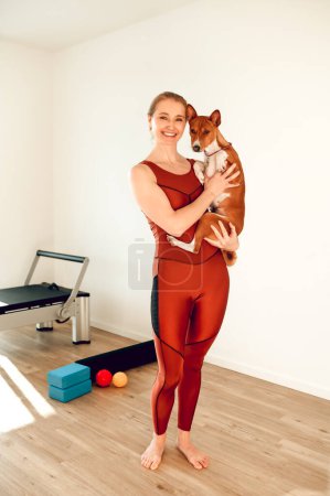 Téléchargez les photos : Femme séduisante sportive tenant un chien en cours de fitness - en image libre de droit