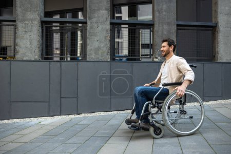 Téléchargez les photos : Invalidité. Brune jeune homme caucasien chevauchant un fauteuil roulant - en image libre de droit