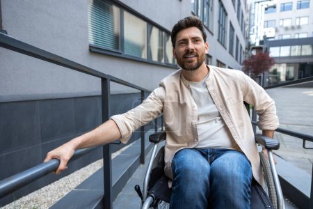 Téléchargez les photos : Handicapés. Jeune homme barbu aux cheveux bruns en fauteuil roulant - en image libre de droit