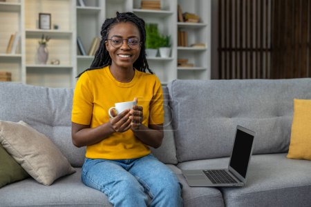 Téléchargez les photos : Jeune femme travaillant à la maison et prenant le café du matin - en image libre de droit