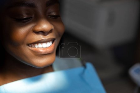 Téléchargez les photos : Patiente recevant un traitement dentaire montrant des dents blanches parfaites - en image libre de droit