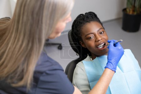 Photo for Smiling multicultural lady in dental clinic doing teeth checkup - Royalty Free Image