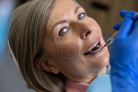 Photo for Woman sitting in dental chair teeth treatment in dentistry - Royalty Free Image