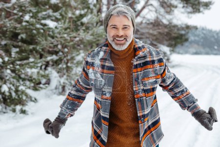 Photo for Winter activity. Mature happy man feeling excited in a winter snowy park - Royalty Free Image