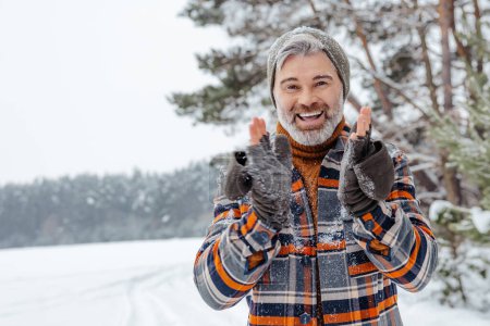 Téléchargez les photos : Activité hivernale. Homme heureux mature se sentant excité dans un parc enneigé d'hiver - en image libre de droit