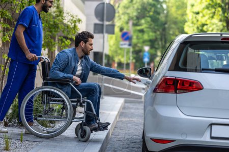 Téléchargez les photos : Véhicule pour homme handicapé. . Un homme en fauteuil roulant monte dans une voiture - en image libre de droit