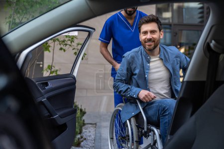Photo for Getting in a car. Disabled man getting on a car, male nurse helping him - Royalty Free Image