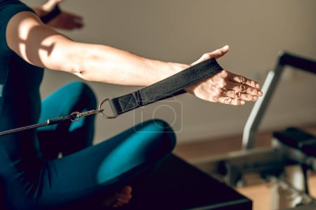 Téléchargez les photos : Athlète féminine méconnaissable utilisant l'équipement Pilates à la salle de gym présentant son mode de vie actif et sain - en image libre de droit