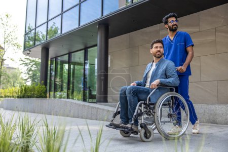 Photo for Nurse and patient. Male nurse in a blue doctors overall with a wheelchair - Royalty Free Image