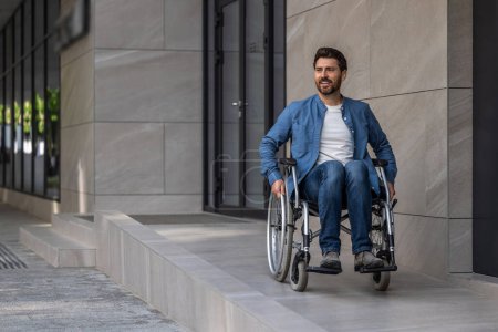 Photo for Disabled man. Young bearded man riding a wheelchair in a hospital yard - Royalty Free Image