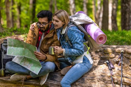 Photo for Searching for the route. Couple of travelers searching for the route on the map and looking involved - Royalty Free Image