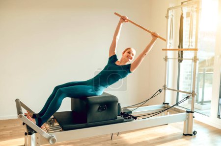 Téléchargez les photos : Moniteur femme en cours de yoga promouvoir un mode de vie sain et l'activité physique dans le studio Pilates. - en image libre de droit