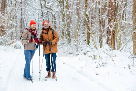 Happy people. Smiling man and woman of middle age in a winter forest looking happy