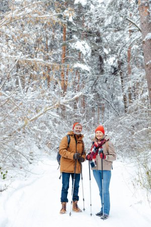 Téléchargez les photos : Des gens heureux. Homme et femme souriants d'âge moyen dans une forêt d'hiver, heureux - en image libre de droit