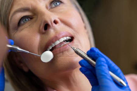 Téléchargez les photos : Femme assise dans une chaise dentaire traitement des dents en dentisterie - en image libre de droit
