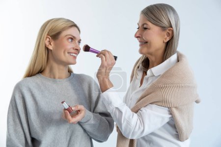Photo for Beauty tricks. Two beautiful women doing make up and looking contented - Royalty Free Image