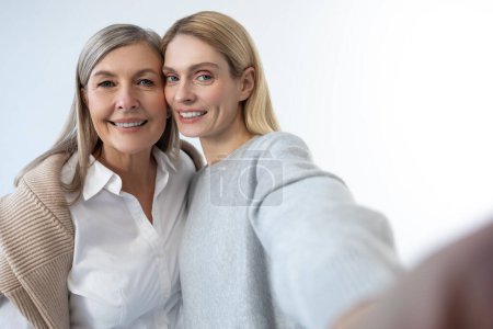 Photo for Happy moments. Two good-looking women looking happy and making selfie - Royalty Free Image