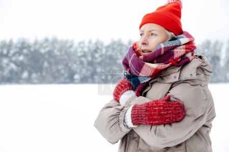 Téléchargez les photos : J'ai froid. Chapeau rouge femme et écharpe à carreaux sensation de froid et frissons - en image libre de droit