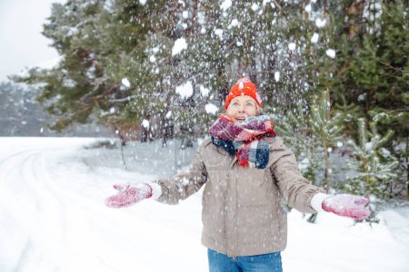 Foto de Magia de invierno. Emocionada mujer sintiéndose disfrutada en un bosque nevado de invierno - Imagen libre de derechos