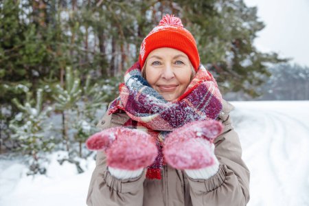 Photo for Snowy weather. Happy mature woman enjoying snowy weather in a forest - Royalty Free Image