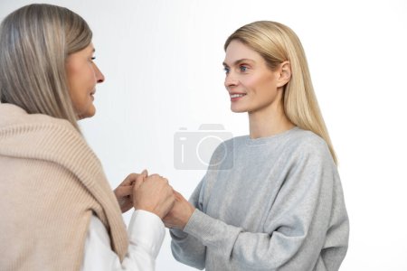 Photo for Closeness. Mother and daughter standing close and holding hands - Royalty Free Image