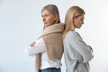 Photo for Misunderstanding. Mom and daughter standing back to back with serious look - Royalty Free Image