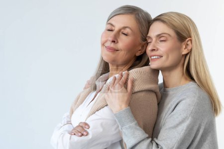 Photo for Tenderness. Blonde young woman hugging her mom and looking peaceful - Royalty Free Image