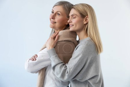 Photo for Love and care. Blonde young woman hugging her mom and looking peaceful - Royalty Free Image