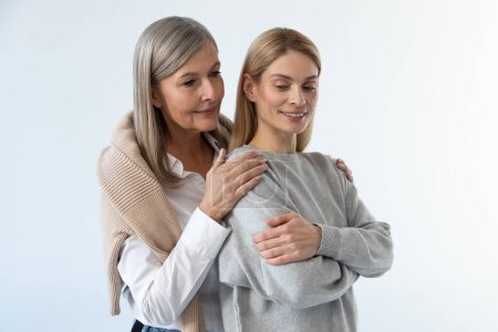 Photo for Caring mom. Gray-haired good-looking woman hugging her daughter with tenderness - Royalty Free Image
