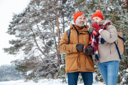 Téléchargez les photos : L'hiver. Deux personnes debout sur un grand fond d'arbre dans une forêt d'hiver - en image libre de droit