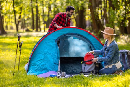 Téléchargez les photos : Voyageurs. Les voyageurs rassemblent la tente et leurs vêtements après s'être reposés dans la forêt - en image libre de droit