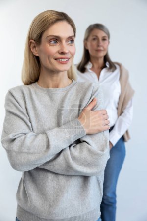 Photo for Confidence. Blonde long-haired woman standing, her mom standing behind - Royalty Free Image